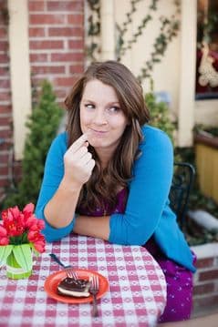 Portrait of Steph Hopkins, MS, RD, seated at a café table with tulips and a plate nearby.